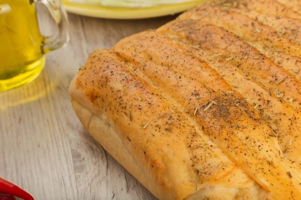 Pie with cabbage and mushrooms on a wooden background with ingredients.