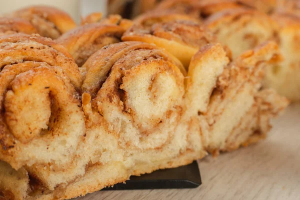 Torta com canela e açúcar em um fundo de madeira . — Fotografia de Stock