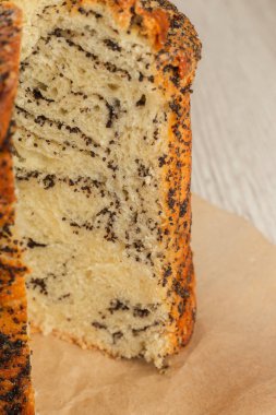 Bir kesim ahşap arka plan üzerinde haşhaş ile pasta.