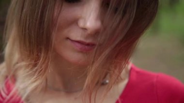 Kırmızı elbiseli çok güzel ve şık bir kadın ormanda yürür.