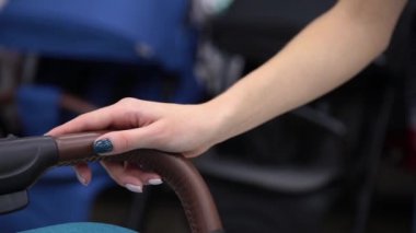 Bir kadın bir bebek arabası onun eliyle tutuyor yakın çekim.