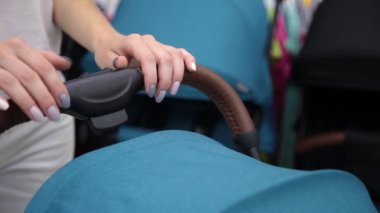 Bir kadın bir bebek arabası onun eliyle tutuyor yakın çekim.