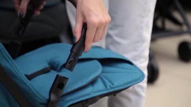 Kamera bir çocuk deposundaki bir bebek arabası katlama işlemi.