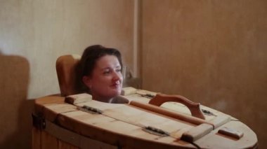 Kadın baş sedir varil bir spa salonu dışına taşıyorsa. Sarışın kadın cesedi kurtarılması için buhar prosedür banyoda geçer..