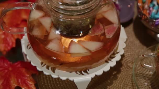 Um bule de vidro com chá quente está sobre a mesa . — Vídeo de Stock