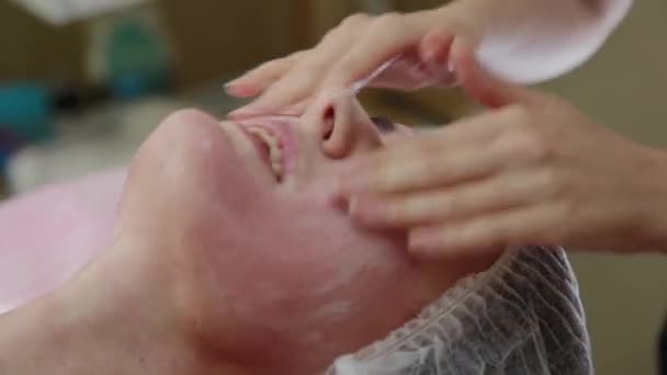 Дуже красива дівчина робить масаж обличчя в спа-салоні. Здоровий спосіб життя . — стокове відео