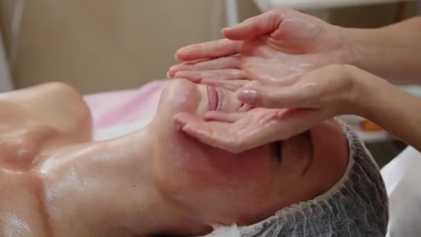 Menina muito bonita fazendo massagem facial no salão de spa. Estilo de vida saudável . — Vídeo de Stock