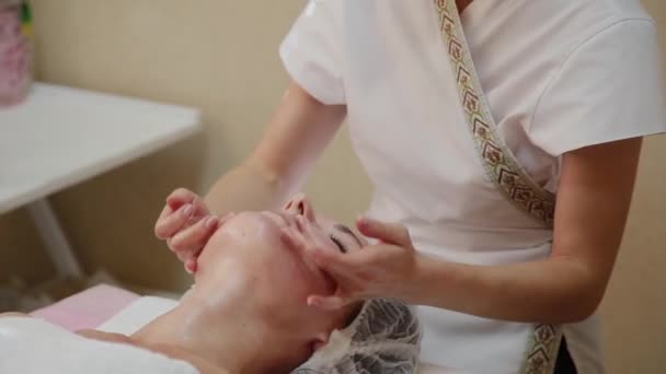 Çok güzel bir kız spa salon yüz masajı yapıyor. Sağlıklı yaşam tarzı. — Stok video