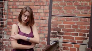 Kız demir merdiven alır ve evler ile avluda duruyor.