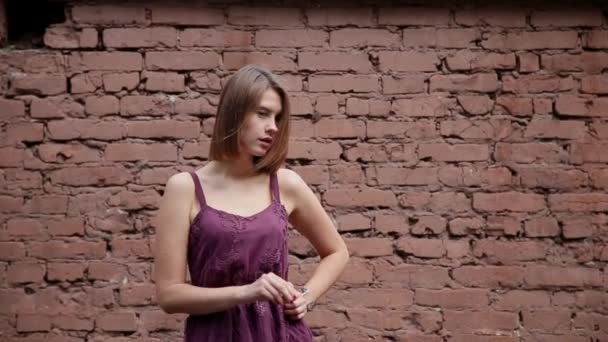 Chica muy hermosa posando en el viejo patio de casas de ladrillo . — Vídeo de stock