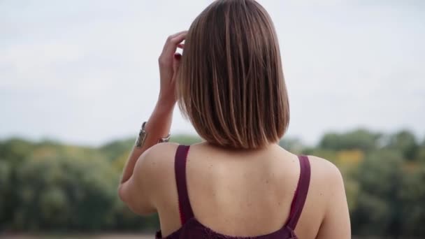 Дуже красива і сексуальна дівчина стоїть на мосту і дивиться на відстань . — стокове відео
