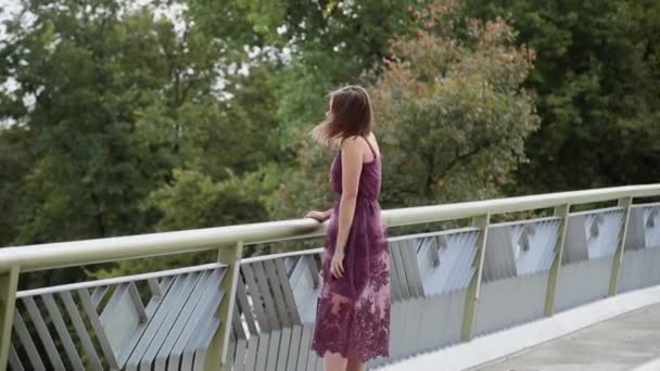 Une fille très belle et sexy se tient debout sur le pont et regarde au loin . — Video