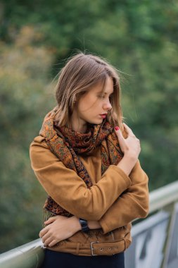 Çok güzel bir kız bir demir köprü üzerinde duruyor ve kameraya poz.