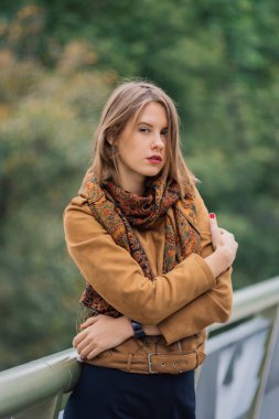 Çok güzel bir kız bir demir köprü üzerinde duruyor ve kameraya poz.