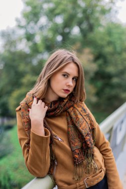 Çok güzel bir kız bir demir köprü üzerinde duruyor ve kameraya poz.