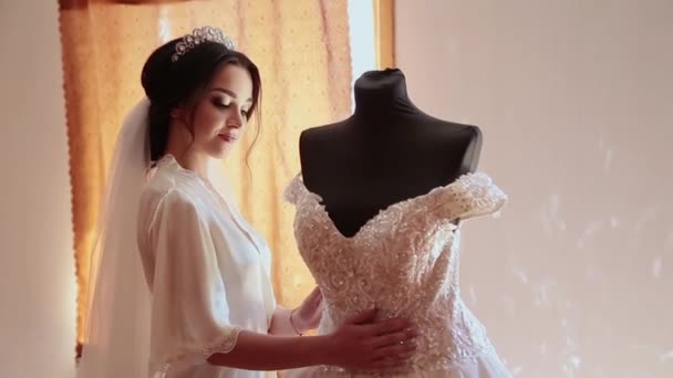 Bardzo piękna dziewczyna dotyka jej suknia ślubna. — Wideo stockowe