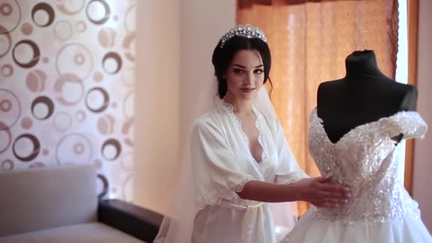 Sehr schönes Mädchen berührt ihr Hochzeitskleid. — Stockvideo