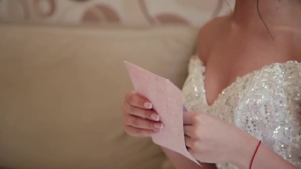 Πολύ όμορφη νύφη ανοίγει και διαβάζει μια επιστολή από ένα αγαπημένο πρόσωπο. — Αρχείο Βίντεο