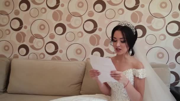 Sehr schöne Braut öffnet und liest einen Brief von einem geliebten Menschen. — Stockvideo
