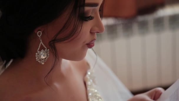 Zeer mooie bruid opent en leest een brief van een geliefde. — Stockvideo