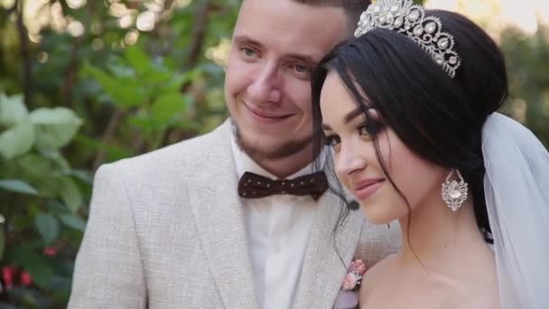 Les jeunes mariés s'embrassent et s'amusent le jour de leur mariage . — Video