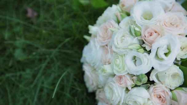 Beautiful wedding bouquet lies on the grass. — Stock Video