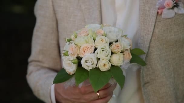 Bräutigam mit Blumenstrauß im Stadtpark. — Stockvideo