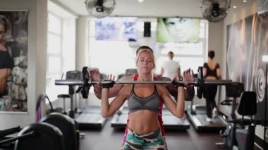 Jimnastik salonu bir kadın fitness eğitmen yardımıyla tatbikatlar yapar.