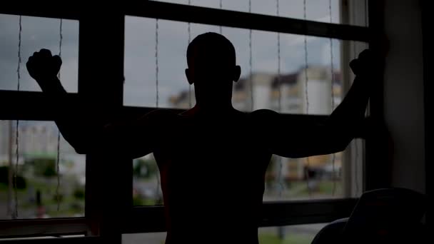 Мужчина позирует возле окна в спортзале . — стоковое видео