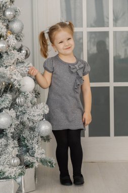 Küçük bir kız tarafından bir Noel ağacı duran ve oyuncaklar dokunmadan.