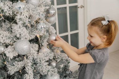 Küçük bir kız tarafından bir Noel ağacı duran ve oyuncaklar dokunmadan.