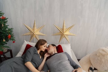 Parlak bir Noel sabahı yatakta mutlu bir aile. Yeni yıl 2019.