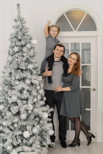 Família feliz e bela de três em um quarto de Ano Novo brilhante festivo . — Fotografia de Stock