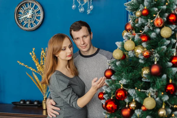 Très beau couple amoureux debout et câlin dans une chambre du Nouvel An avec décor . — Photo