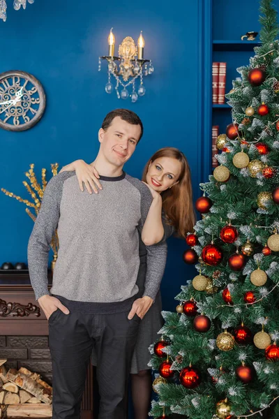 Mycket vackert par i kärlek står och kramas i ett nytt år rum med inredning. — Stockfoto