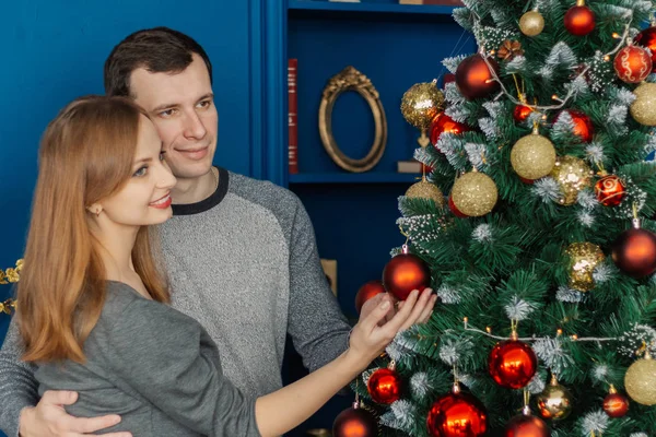 Très beau couple amoureux debout et câlin dans une chambre du Nouvel An avec décor . — Photo