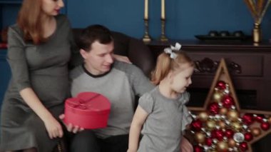 Üç kişilik bir aile yeni yıl hediyeleri Noel 2019 şömine yakın açar.