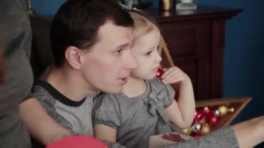 Üç kişilik bir aile yeni yıl hediyeleri Noel 2019 şömine yakın açar.