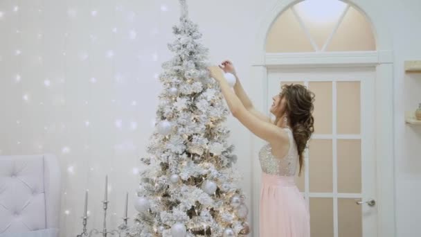 Sehr schönes Mädchen schmückt den Weihnachtsbaum. — Stockvideo