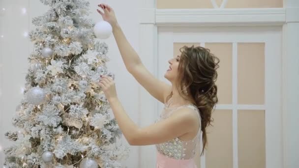 Menina muito bonita decora a árvore de Natal . — Vídeo de Stock