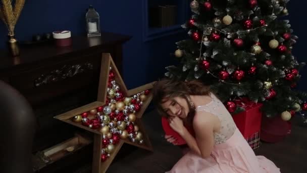 Mycket vacker flicka håller en ny år gåva i hennes händer. — Stockvideo