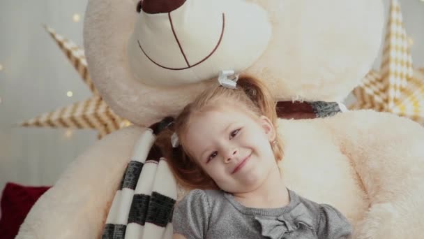 Little and very beautiful girl playing with a new years bear. — Stock Video