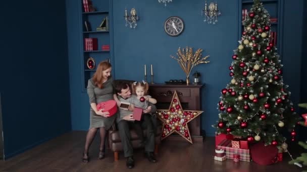 Una Familia Tres Abre Regalos Año Nuevo Cerca Chimenea Navidad — Vídeo de stock