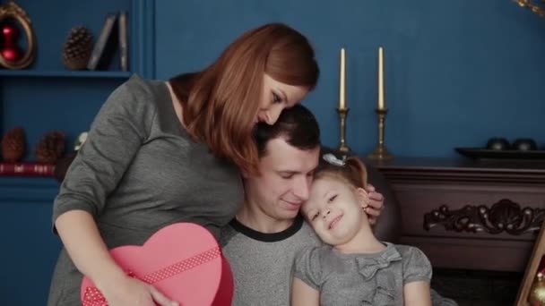 A family of three opens New Years gifts near the fireplace, Christmas 2019. — Stock Video