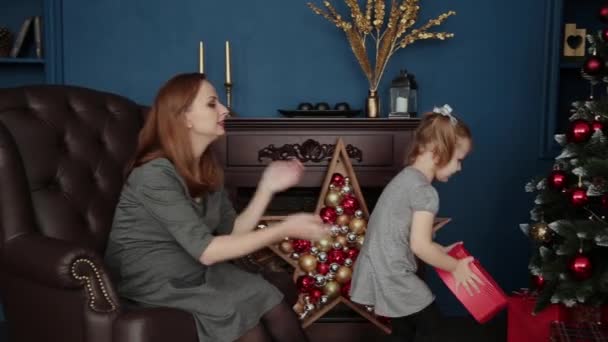 La ragazza apre un regalo di Capodanno con sua madre, Natale 2019 . — Video Stock