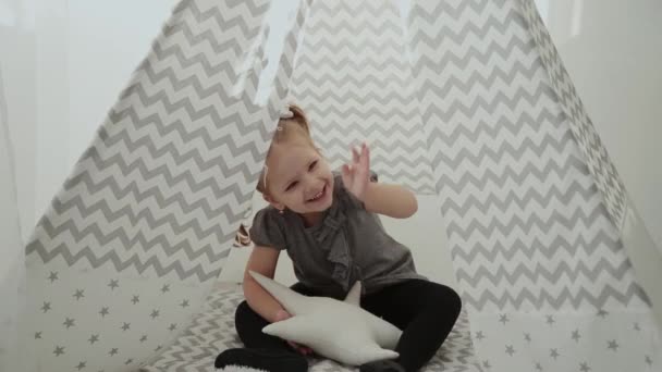 Muy hermosa y niña jugando en un tipi . — Vídeo de stock