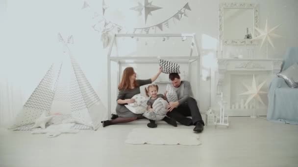 Веселая семья бросает подушки друг в друга в новогоднюю комнату . — стоковое видео