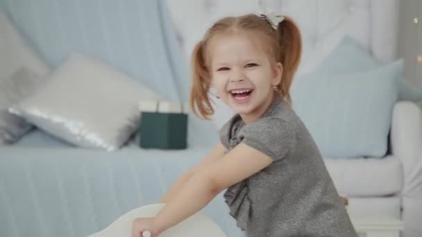 Sehr Schönes Kleines Mädchen Das Neujahrszimmer Auf Einem Holzpferd Reitet — Stockvideo