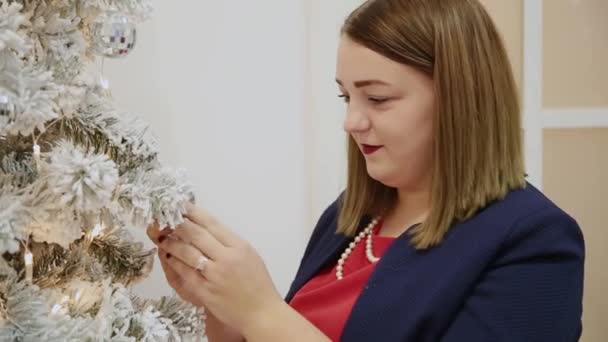 Πολύ όμορφη κοπέλα στολίζει το χριστουγεννιάτικο δέντρο. — Αρχείο Βίντεο