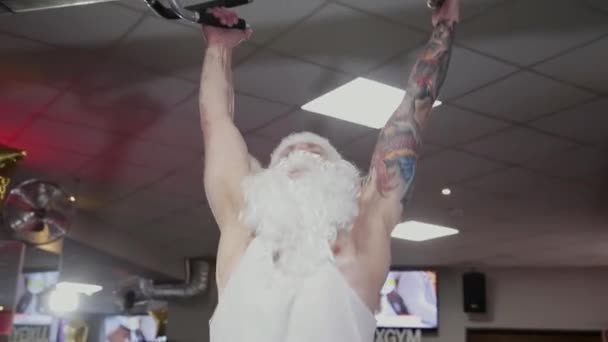 Babbo Natale in palestra si tira su sulla barra orizzontale . — Video Stock